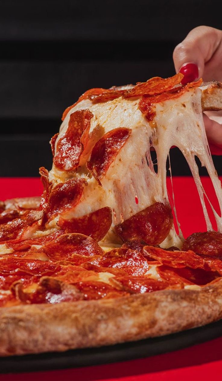 Ein Stück Diavola wird von der Pizza gehoben