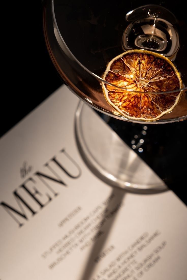 Ein Cocktail mit getrockneter Orange auf einer aufgeschlagenen Karte